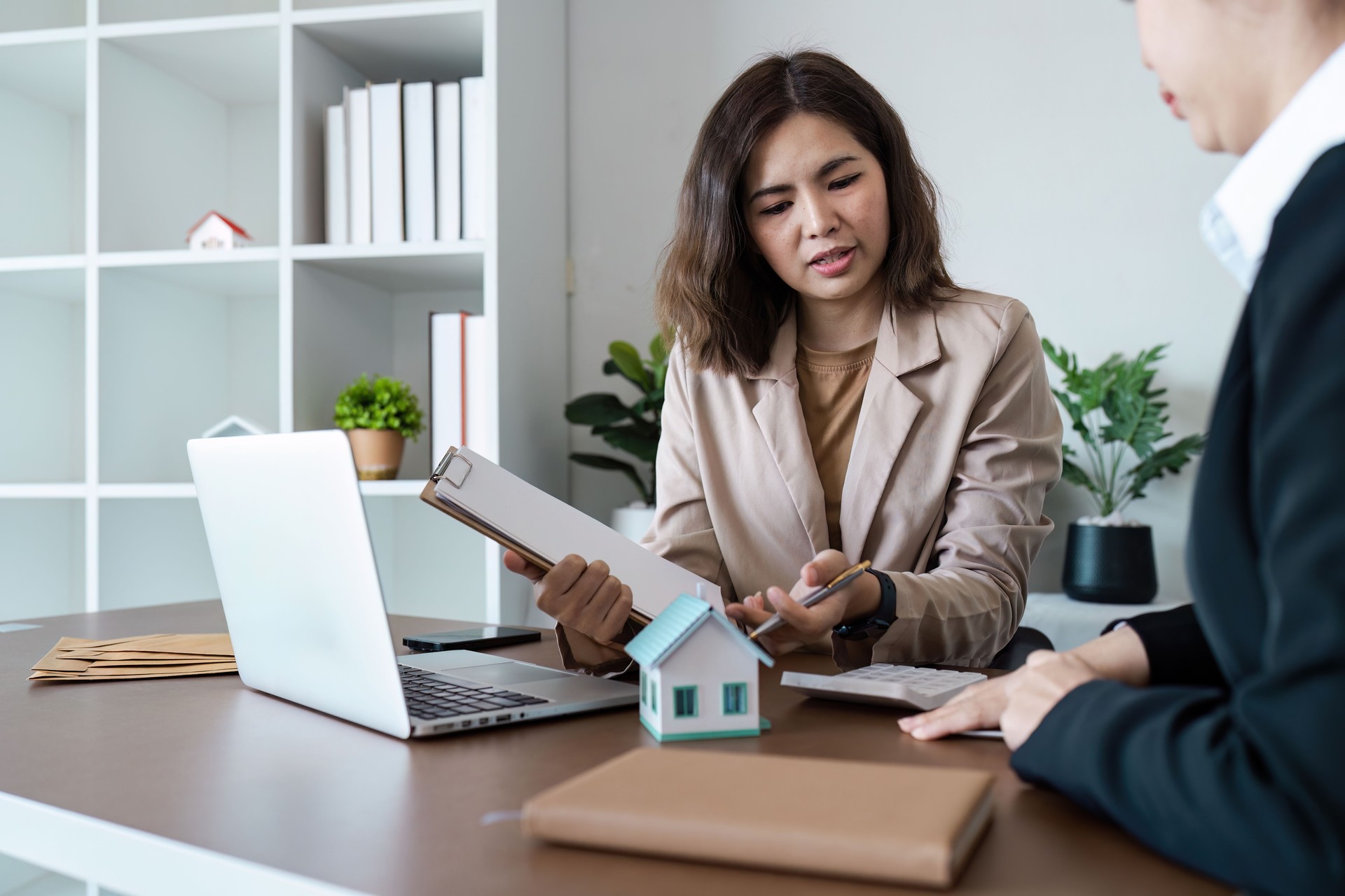 Professional Real Estate Agent Discussing Property Details with Client in Modern Office Setting